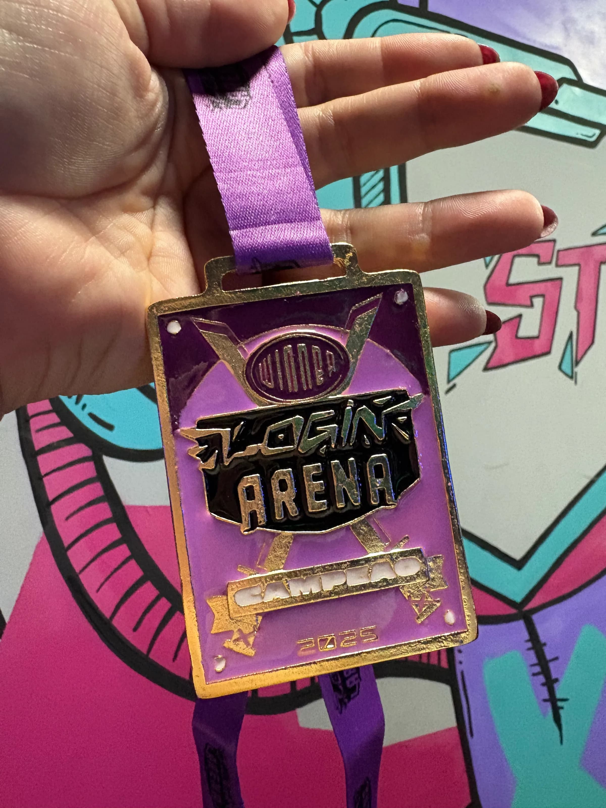 Medalha oficial Login Arena 2026 em close, com grafite colorido atrás.